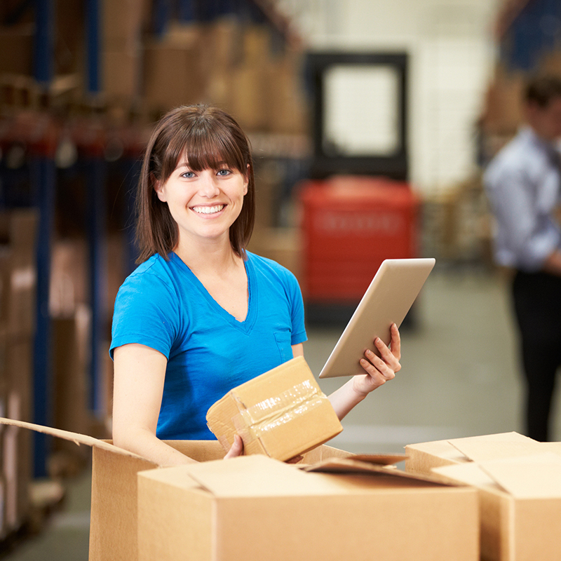 Worker In Warehouse Checking Boxes Using Digital Tablet